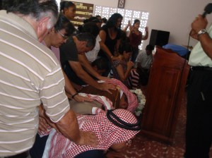 Hermanos nazarenos imponen manos sobre los Misioneros de Proyectos Isaías y Caleb en el culto misionero al regresar del campo